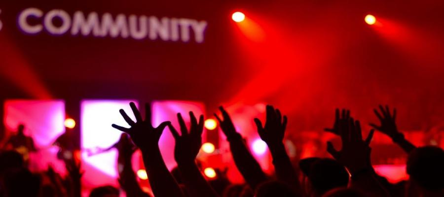 People raising hands below a sign saying "community"