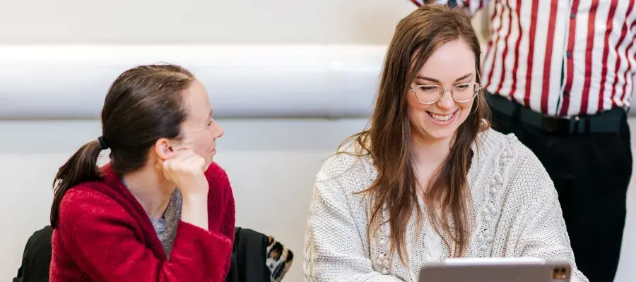 2 woman in a classroom looking at a laptop