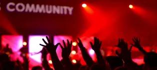 People raising hands below a sign saying "community"