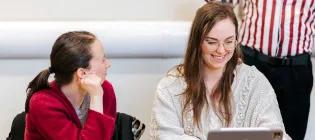 2 woman in a classroom looking at a laptop