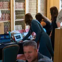 People doing work on computers; working on AV for the event