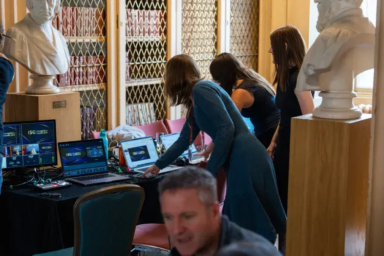 People doing work on computers; working on AV for the event