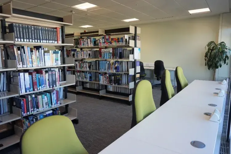 Photograph from inside the self-service study space at the western general hospital, showing a row of chairs at a desk and books behind the chairs.