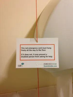 Toilet Cord sign provided by Euan's Guide. It reads: This red emergency cord must hang freely all the way to the floor. If it does not, it may prevent a disabled person from asking for help.