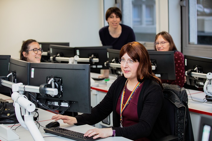 Staff at computer lab working and smiling