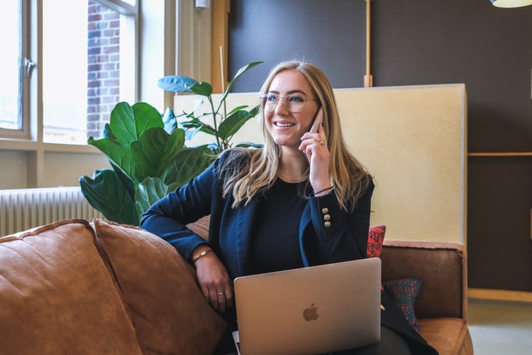 Woman on phone in front of laptop