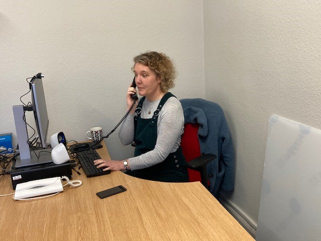 Woman answers phone and types on computer