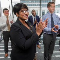 Four staff members standing and clapping